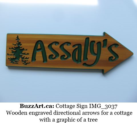 Wooden engraved directional arrows for a cottage with a graphic of a tree